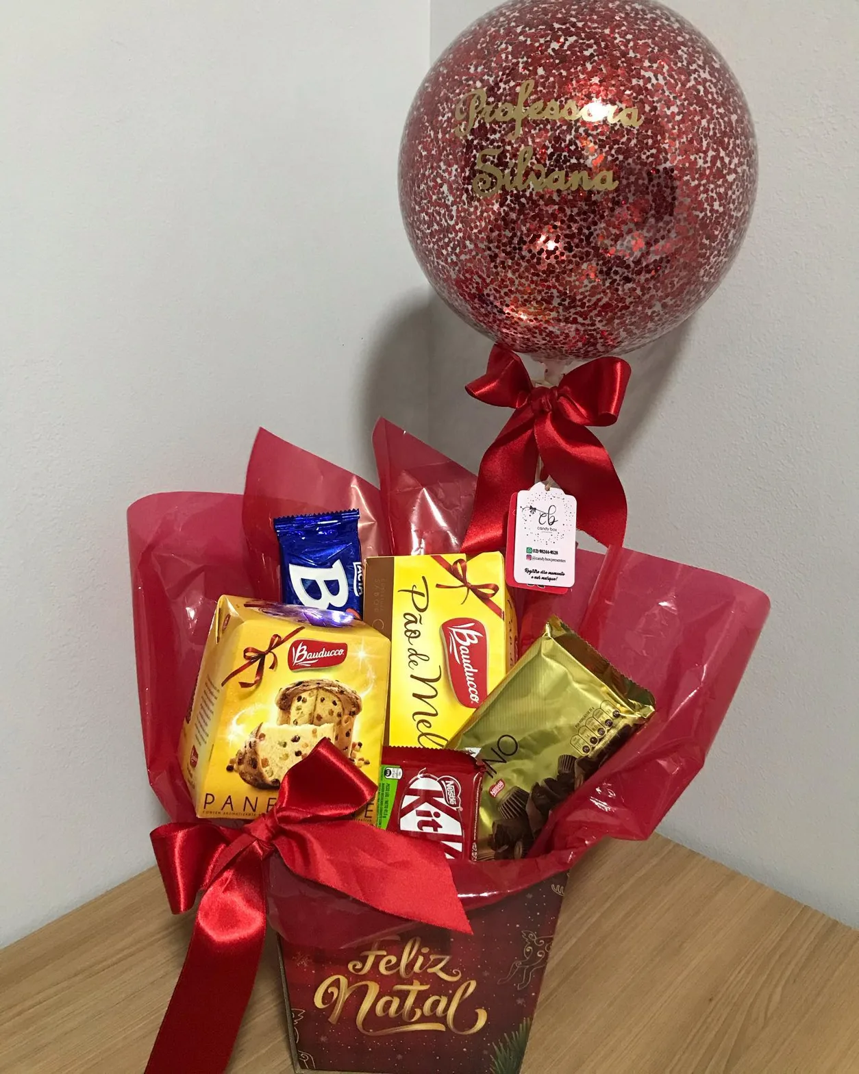 Caixa vermelha com chocolates e balão escrito Feliz Natal